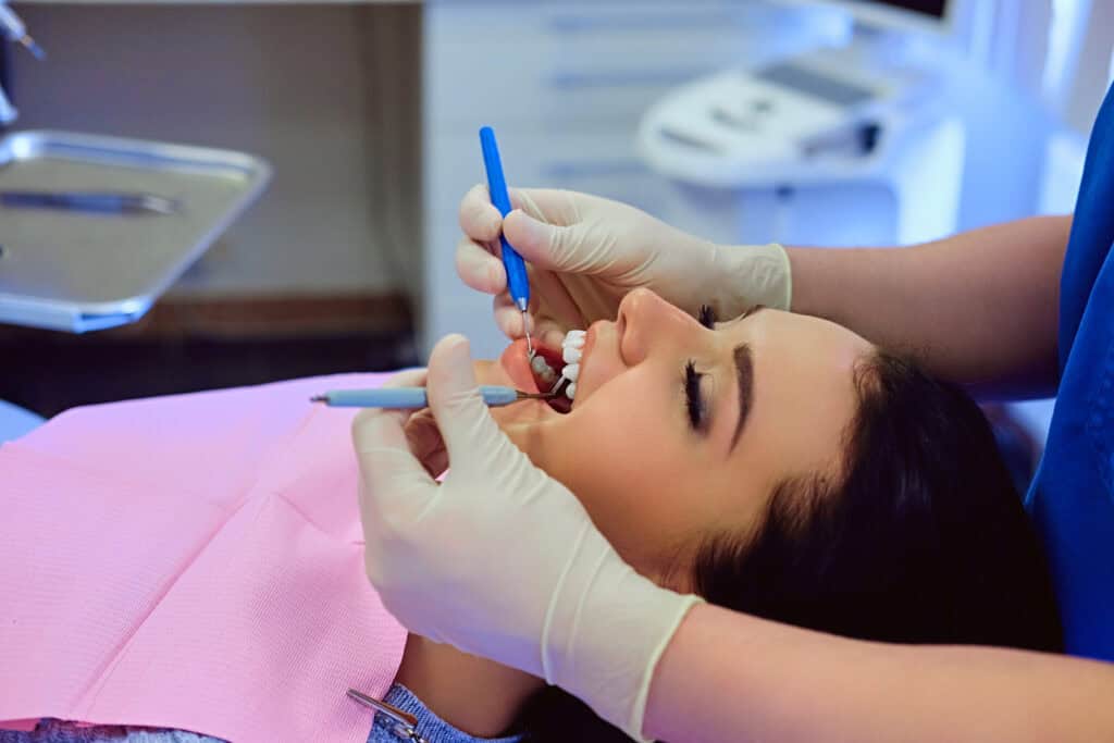 Dentist examining female’s teeth in dentistry. The Role of a Dentist in Managing Oral Health